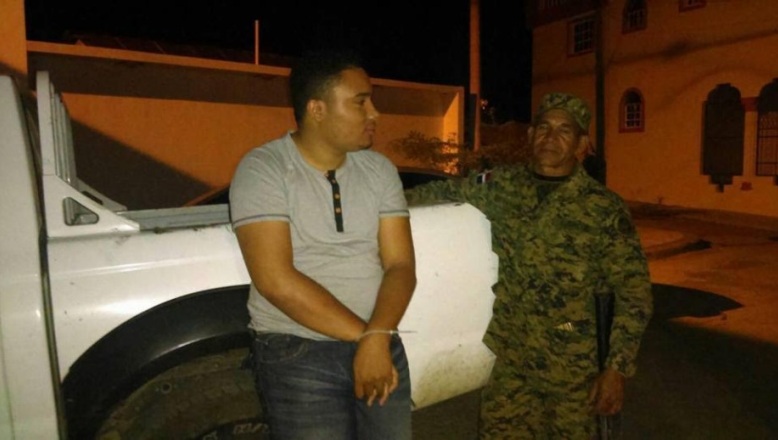 FOTOREPORTERO AMARRADO Y CUSTODIADO POR UN GUARDIA ERD